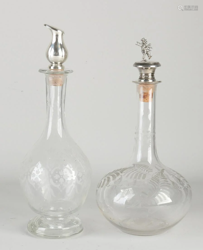 Two antique etched decanters with silver stoppers.