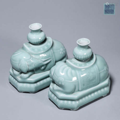 A pair of celadon glazed porcelain elephant-shaped candlesti...