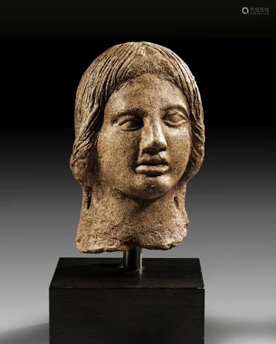 Terracotta votive head of young man with long hair.