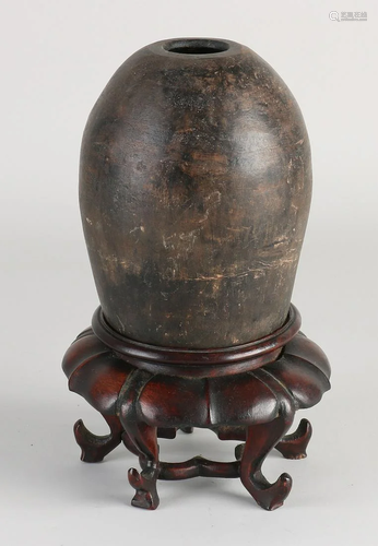 Antique Chinese terracotta jug on carved console.