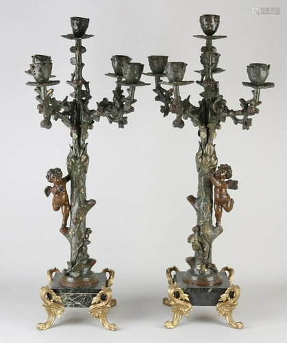 Two large candlesticks with tendrils and putti on