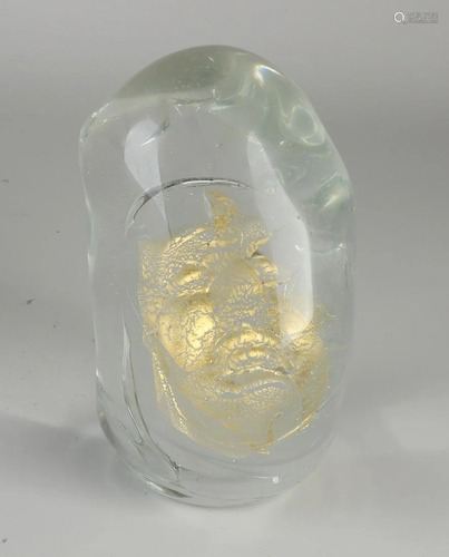 Modern glass object with a golden face incorporated in