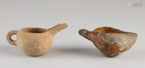 Two antique Persian oil lamps made of terracotta.