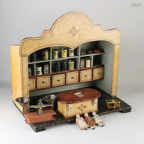 Antique toy doll shop with counter and accessories.