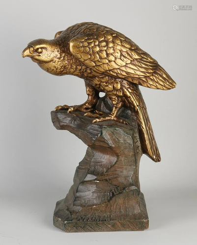 Antique polychrome terracotta bird of prey on a rock.