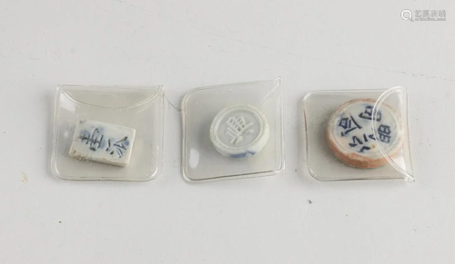 Three old Chinese porcelain tokens or game pieces.