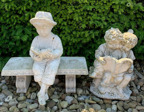 Two concrete garden statues. 1x Boy reads book on