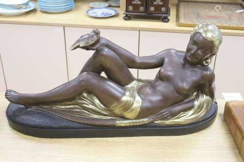 An Art Deco style painted plaster reclining nude holding a d...