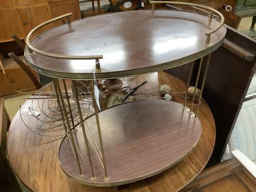 A brass mounted simulated rosewood oval two tier tea trolley...