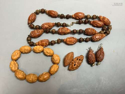 A Chinese peach stone or nut bead necklace, bracelet, a pair...