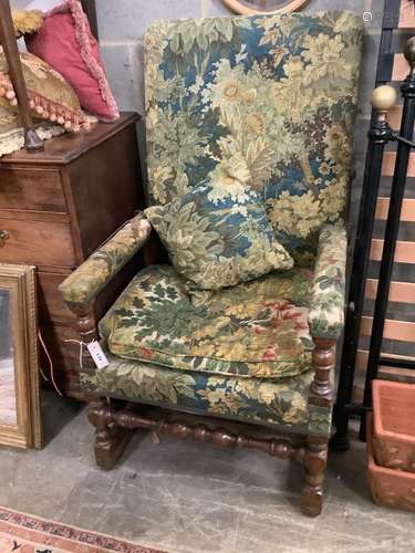 A Jacobean style carved walnut reclining armchair, with tape...