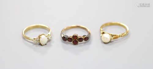 A 9ct yellow gold garnet-set ring, a similar cabochon opal a...