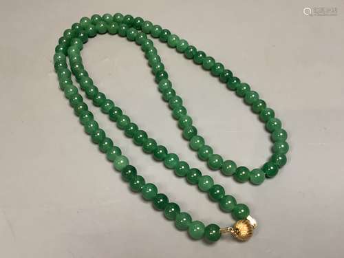 A single strand simulated jade bead necklace with 14k clasp,...