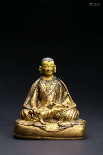 A GILT-BRONZE FIGURE OF SEATED LAMA