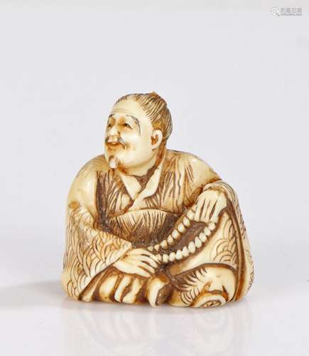 Japanese Edo period ivory netsuke, carved as a man with fold...