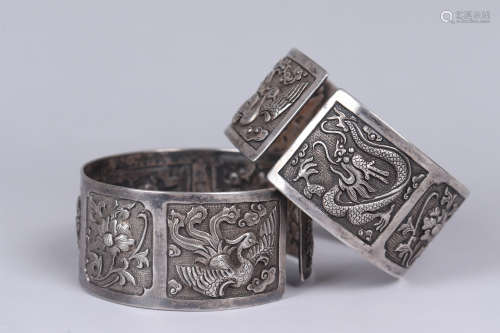 A PAIR OF SILVER DRAGON AND PHOENIX BANGLES