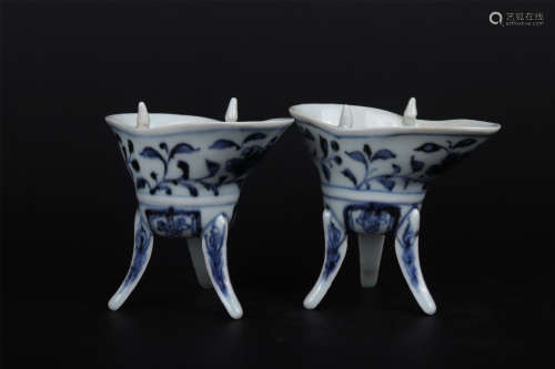 A PAIR OF BLUE AND WHITE INTERLOCKING FLOWERS TRIPOD CUPS