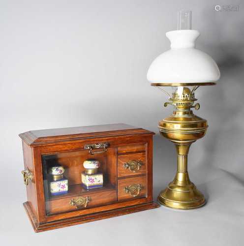 An Edwardian oak desk companion and a brass oil lamp