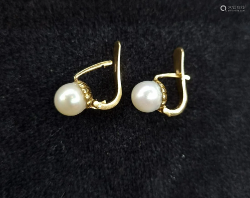 A pair of pearl earrings with an 18k. yellow gold
