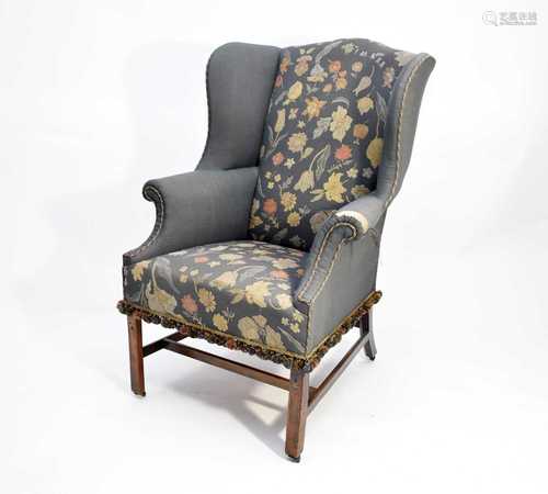 A George III mahogany upholstered wing armchair