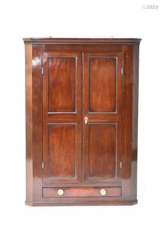 An early-mid 19th century mahogany, hanging corner cupboard