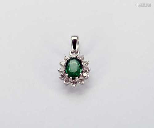 An 18ct white gold oval emerald and diamond cluster pendant