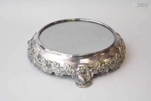 A silver plated mirrored stand