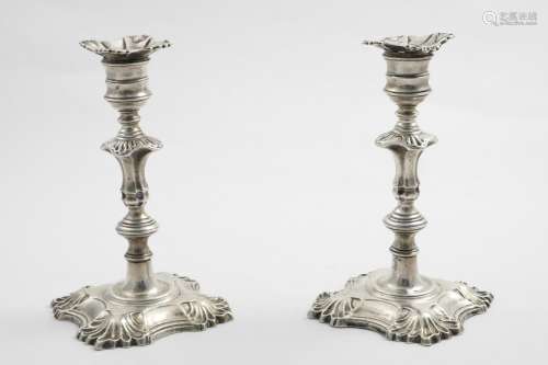 A PAIR OF MID 18TH CENTURY CAST CANDLESTICKS on shaped squar...