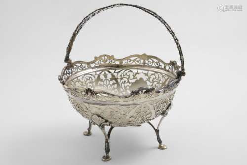 A GEORGE V DECORATIVE SWING-HANDLED BASKET circular with fre...