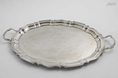 A GEORGE V TWO-HANDLED TRAY of shaped oval outline, initiall...