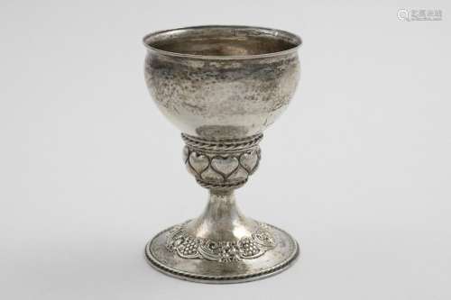 AN EDWARDIAN ARTS & CRAFTS GOBLET on a rising foot, chased w...