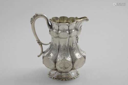 A VICTORIAN ENGRAVED MILK JUG with lobed and fluted decorait...