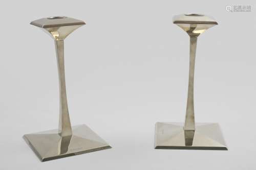 A PAIR OF CONTEMPORARY CANDLESTICKS on shallow, faceted squa...