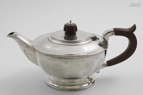 AN ELIZABETH II TEA POT circular with panelled decoration an...