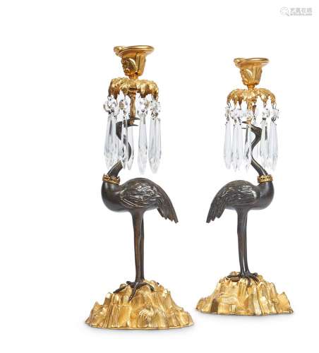 A PAIR OF PATINATED AND GILT BRONZE CANDLESTICKS