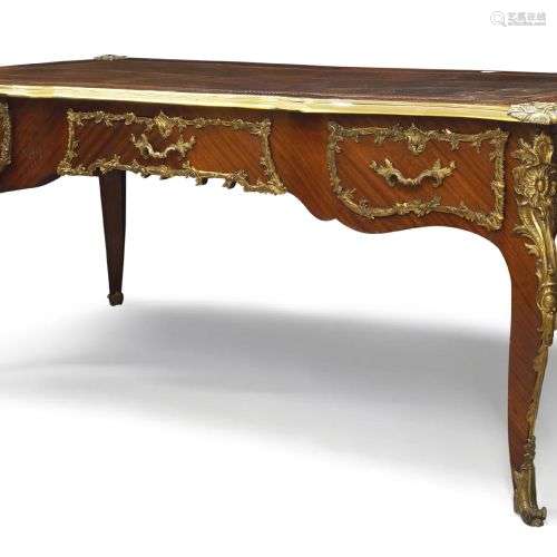 Un bureau plat de style Louis XV en bois de roi et métal dor...