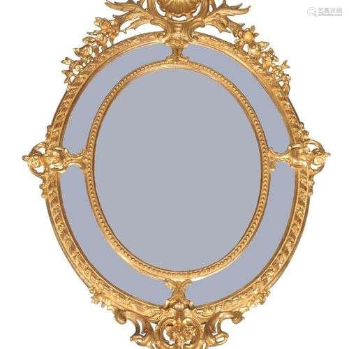 Un miroir marginal ovale en bois doré de style Louis XV, du ...