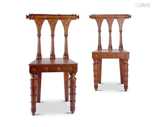 A pair of unusual George IV gothic carved oak hall chairs