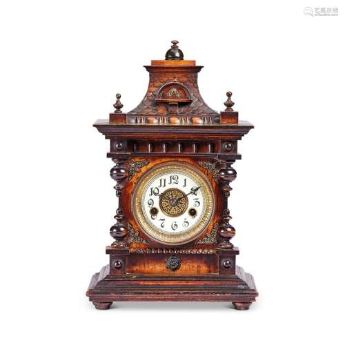 A late 19th century German stained beech carved mantel clock