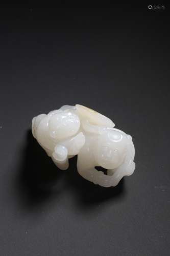 A CARVED WHITE AND RUSSET JADE CHILD HOLDING LOTUS ORNAMENT