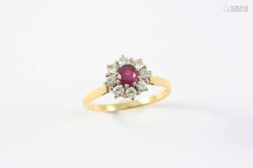 A RUBY AND DIAMOND CLUSTER RING the circular-cut ruby is set...