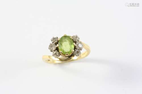 A PERIDOT AND DIAMOND RING the oval-shaped peridot is set wi...