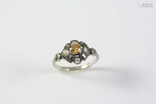 A FANCY COLOURED DIAMOND AND DIAMOND CLUSTER RING centred wi...