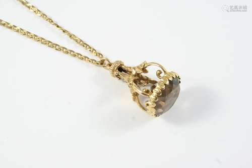 A SMOKY QUARTZ AND GOLD FOB PENDANT the 9ct gold ornate moun...