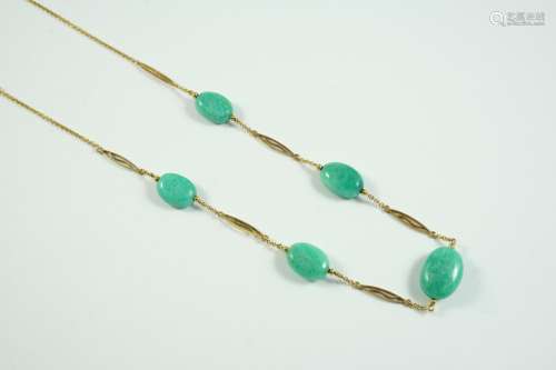 A JADE AND GOLD NECKLACE formed with five oval jade beads, o...