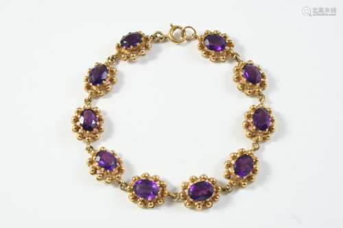 AN AMETHYST AND GOLD BRACELET formed with clusters of oval-s...