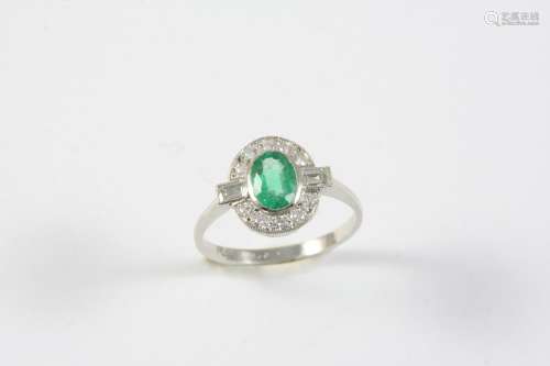 AN EMERALD AND DIAMOND CLUSTER RING the oval-shaped emerald ...