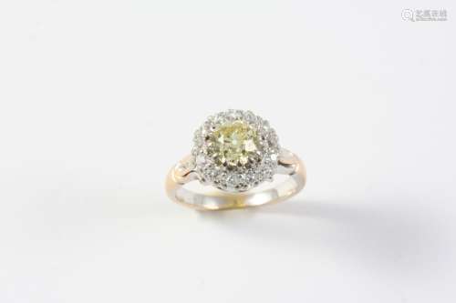 A FANCY YELLOW DIAMOND AND DIAMOND CLUSTER RING the circular...