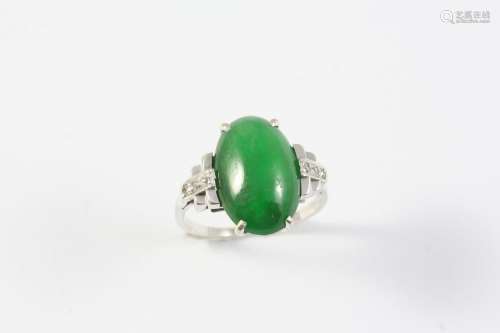 A JADE AND DIAMOND RING the oval-shaped cabochon jade is mou...