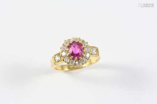 A RUBY AND DIAMOND CLUSTER RING the oval-shaped ruby is set ...